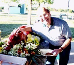 Remington VP Paul Cahan mugs with the roast pig at the final picnic on Friday afternoon.